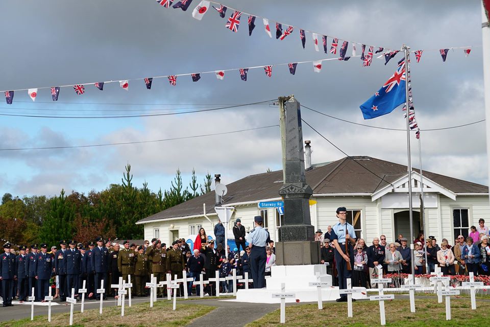ANZAC Day Commemoration - photo of Halcombe War Memorial with white crosses, guard of honour and military personnel on parade.